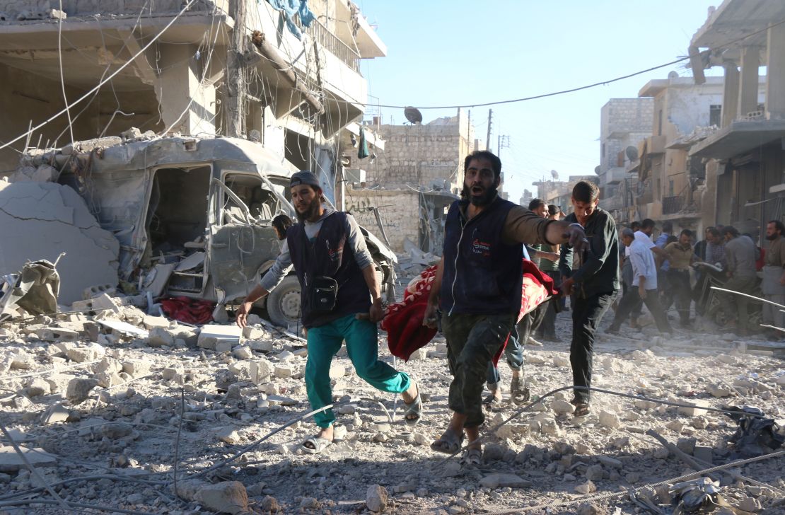 Syrian volunteers carry an injured person following Syrian government forces airstrikes on Aleppo.