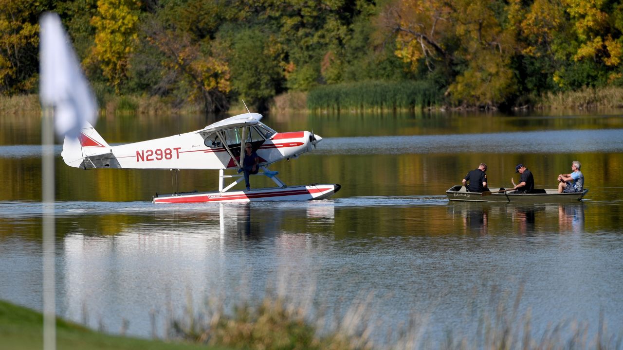 Police pick up an occupant of a sea plane that landed near the seventh green during singles matches.