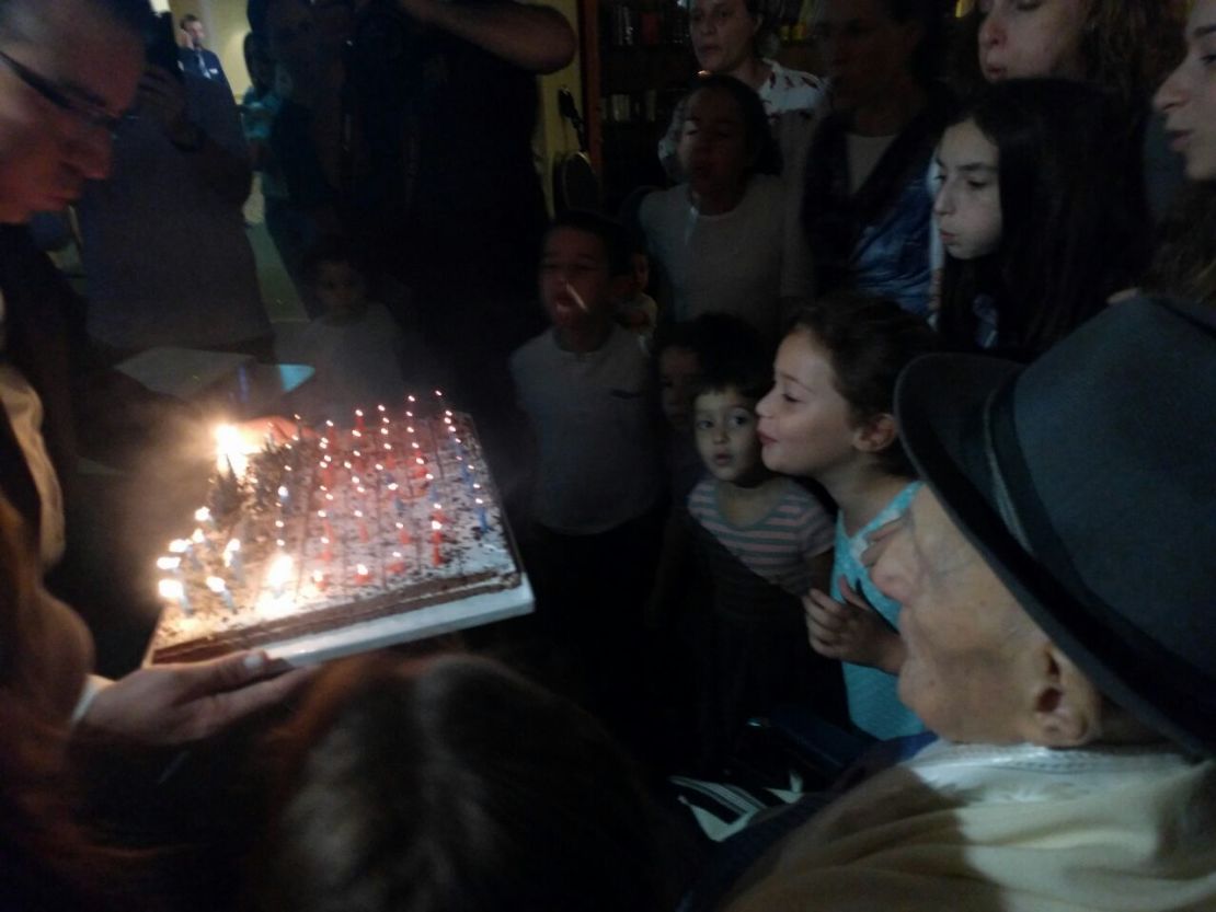 Kristal watches on as younger family members help blow out his candles.