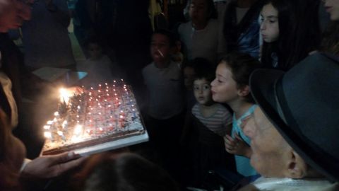 Kristal watches on as younger family members help blow out his candles.