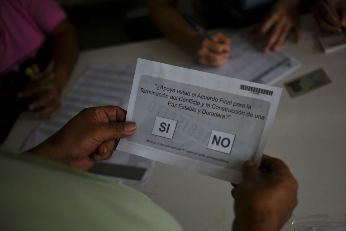 A Colombian receives a ballot before voting in the October referendum.