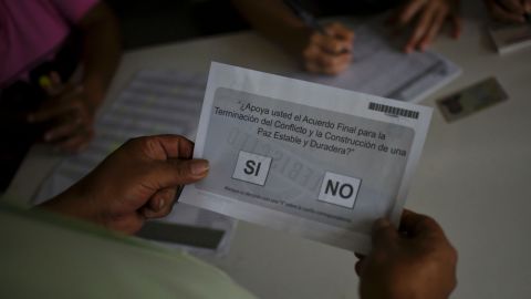A Colombian receives a ballot before voting in the October referendum.