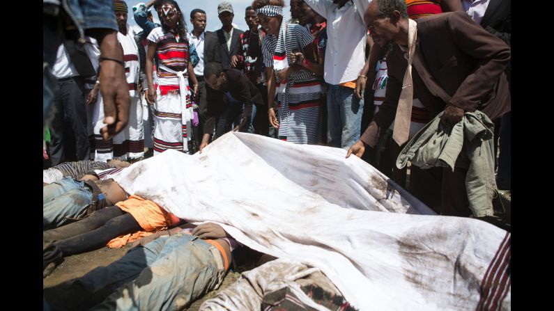 A man covers the bodies of festival goers who were killed in the stampede. 