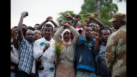 Security forces standby as Oromo people cross their wrists above their heads, a gesture that has become a symbol of Oromo anti-government protests. 