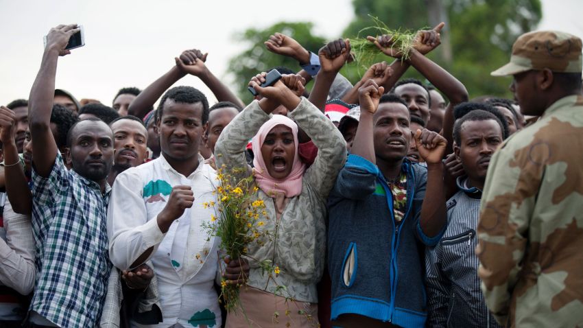 Residents of Bishoftu crossed their wrists above their heads as a symbol for the Oromo anti-government protesting movement during the Oromo new year holiday Irreechaa in Bishoftu on October 2, 2016.
Several people were killed in a stampede near the Ethiopian capital on October 2 after police fired tear gas at protesters during a religious festival, according to an AFP photographer at the scene. Several thousand people had gathered at a sacred lake to take part in the Irreecha ceremony, in which the Oromo community marks the end of the rainy season, where participants crossed their wrists above their heads, a gesture that has become a symbol of Oromo anti-government protests. The event quickly degenerated, with protesters throwing stones and bottles and security forces responding with baton charges and then tear gas grenades. / AFP / Zacharias ABUBEKER        (Photo credit should read ZACHARIAS ABUBEKER/AFP/Getty Images)