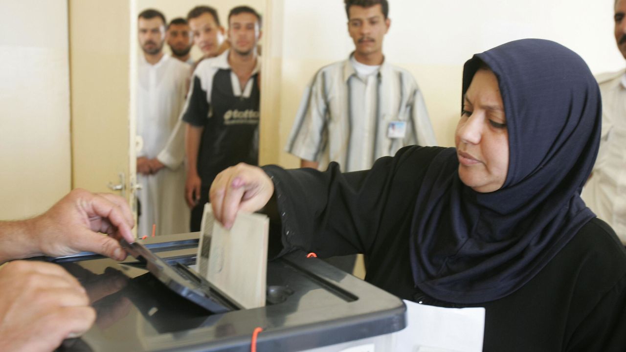 An Iraqi Sunni woman casts her vote at a polling station during a referendum on a new constitution of Iraq in the western town of Fallujah, 15 October 2005.