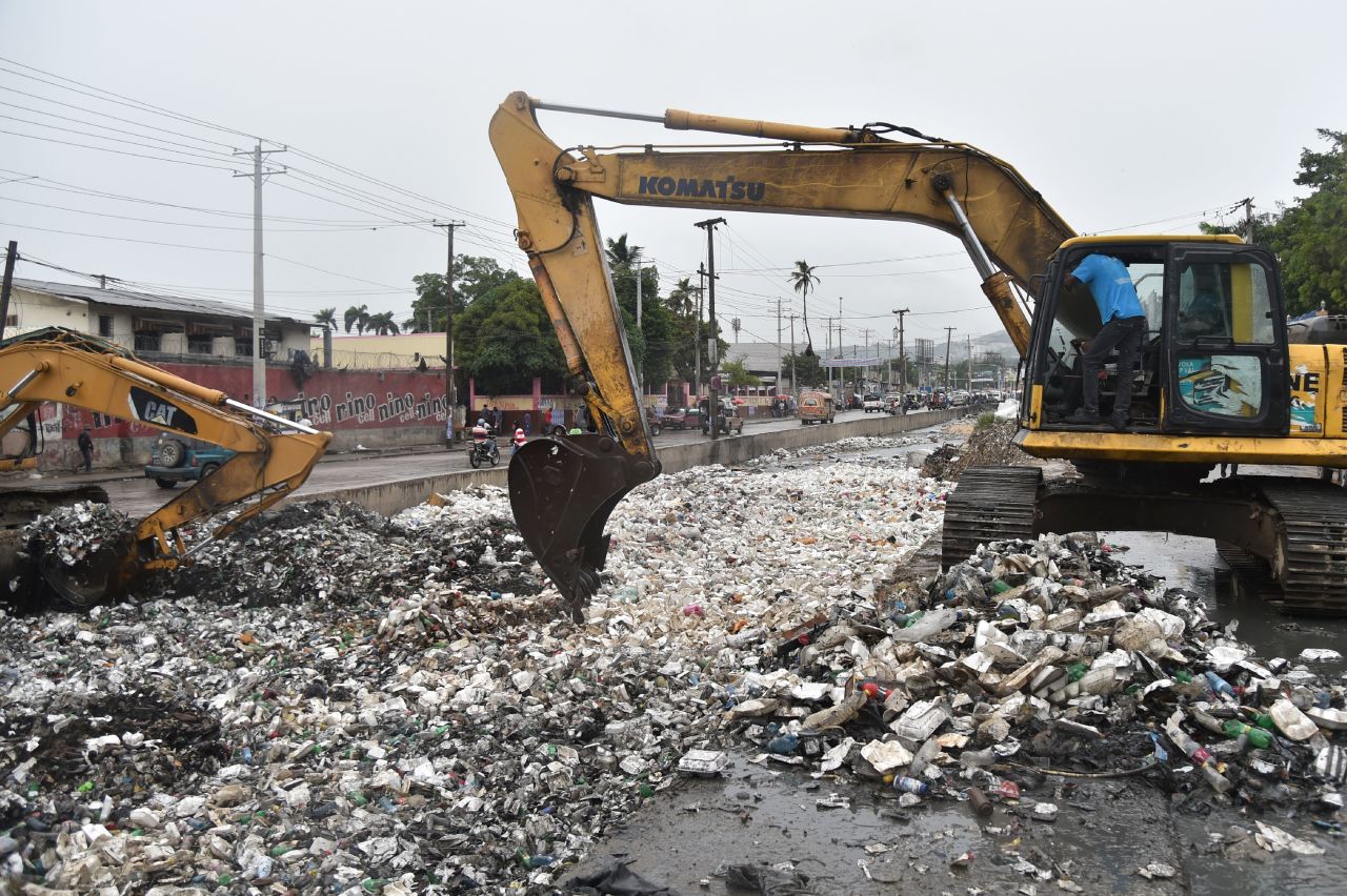 A backhoe removes garbage to clear a canal in Port-au-Prince on October 3.