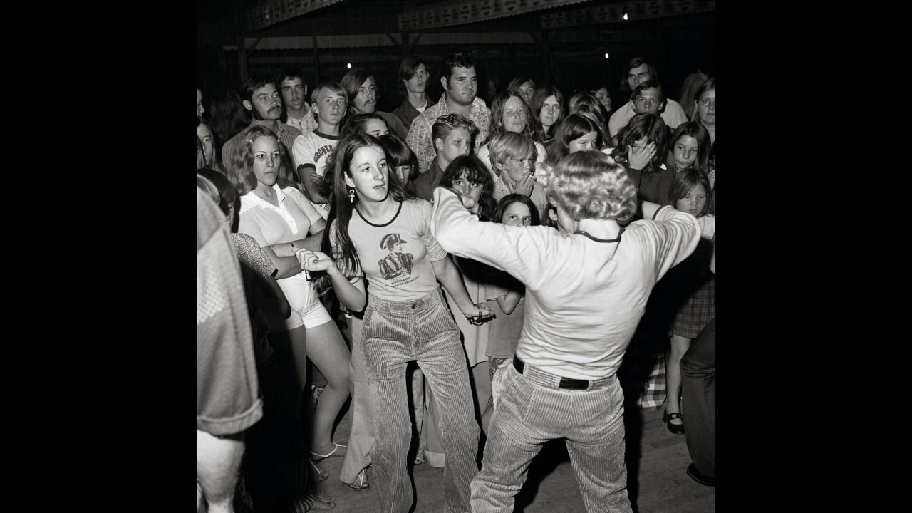 Many of Yates' photos suggest a story. Take this one, for example: While a couple dances in the foreground, the young woman in white glares disapprovingly.