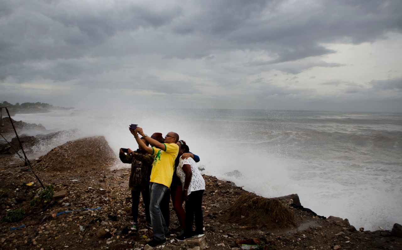 People near Kingston, Jamaica, take a photo in front of the rough surf produced by Hurricane Matthew on October 3.