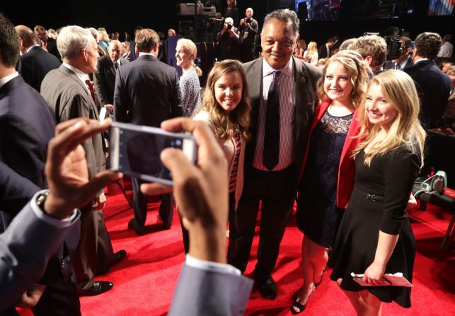 The Rev. Jesse Jackson takes photos with debate attendees prior to the debate.