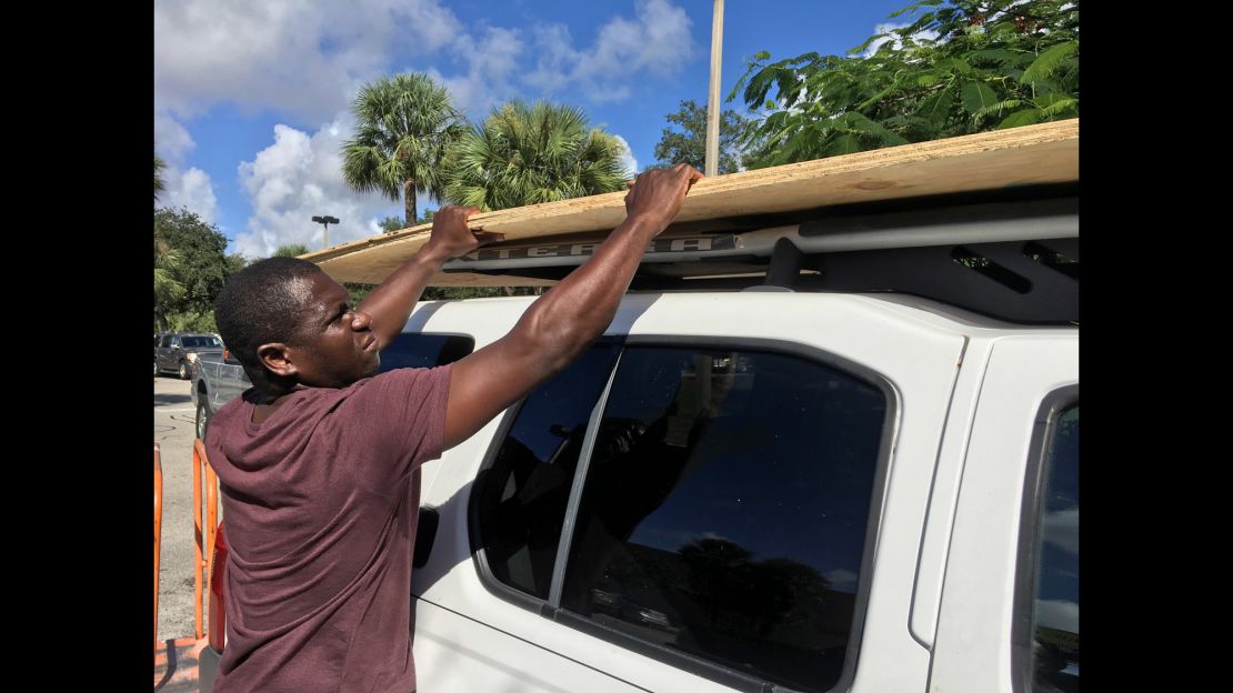 Texroy Spence, of Deerfield Beach, Florida, loads plywood onto his car at the Home Depot on Tuesday.