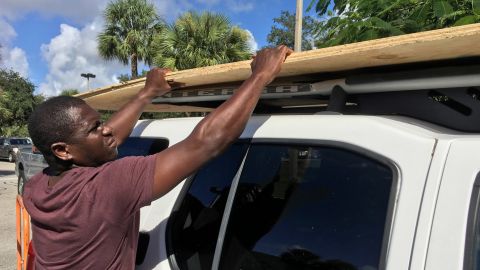 Texroy Spence, of Deerfield Beach, Florida, loads plywood onto his car at the Home Depot on Tuesday.