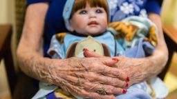 Vivian Guzofsky, 88, holds a baby at Sunrise Senior Living in Beverly Hills, California, on August 2, 2016. Some nursing homes are using a technique called doll therapy to ease anxiety among their residents with dementia.  (Heidi de Marco/KHN)