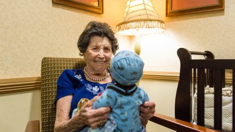 Vivian Guzofsky, 88, holds a baby at Sunrise Senior Living in Beverly Hills, California.