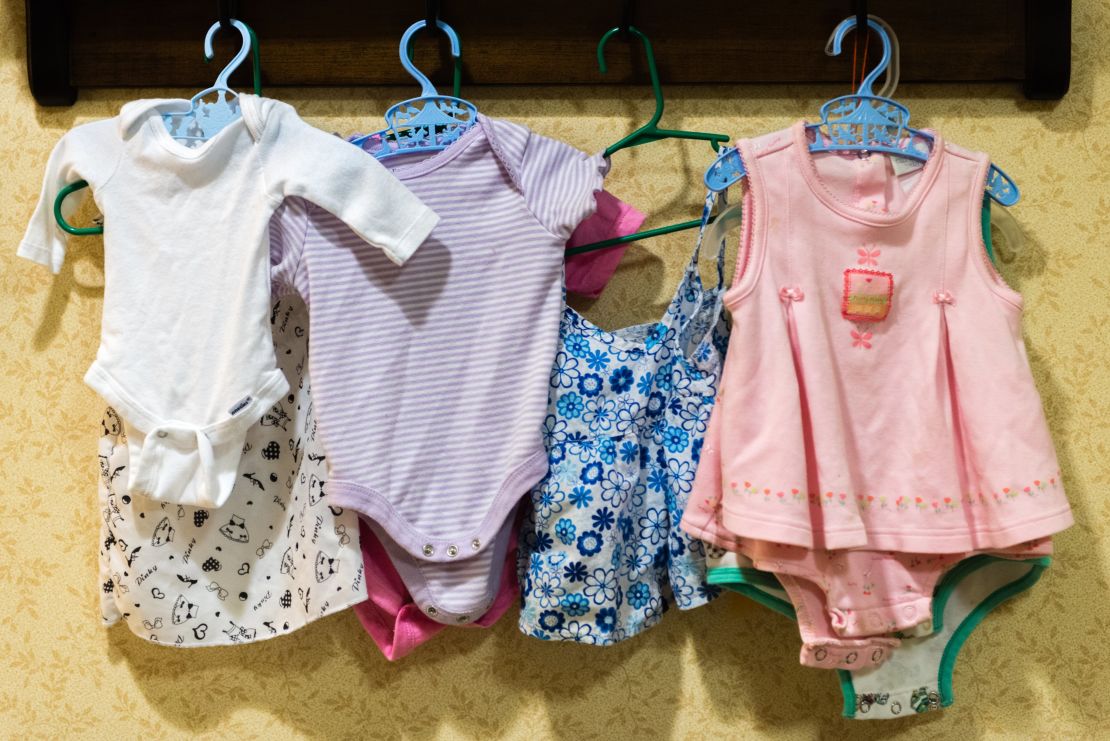 Baby clothes hang on the wall of the nursery area at Sunrise Senior Living.