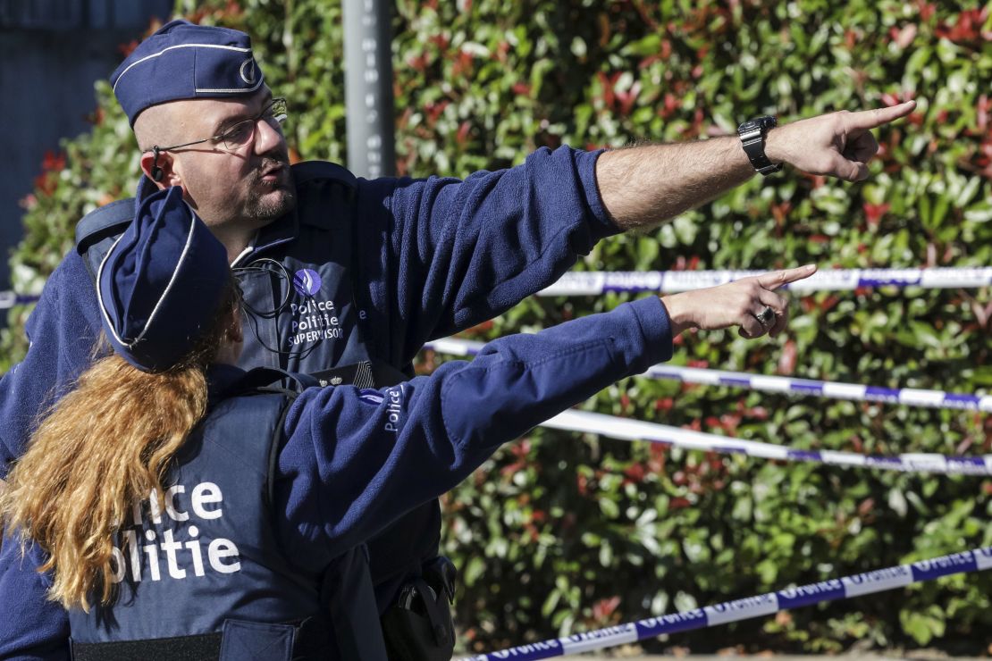 Police investigate the scene where a man stabbed two police officers.