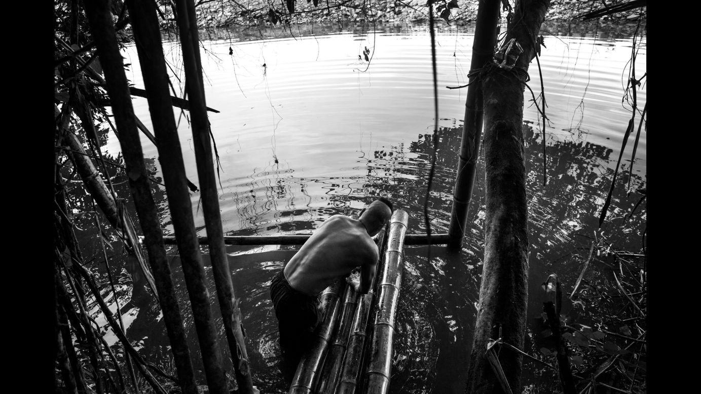 A guerrilla fighter prepares to take a bath in the river.