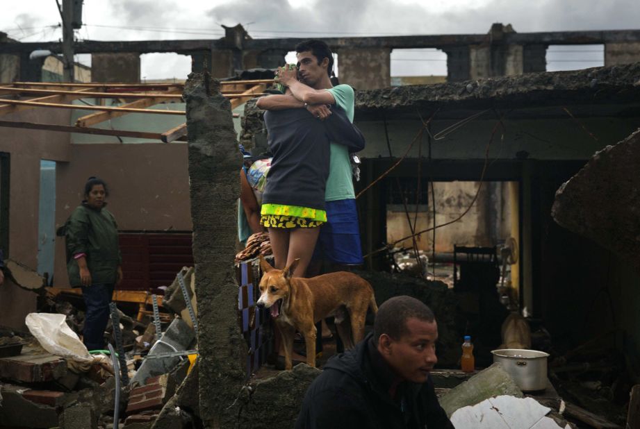 People embrace at their damaged home in Baracoa, Cuba. The hurricane rolled across the sparsely populated tip of Cuba, destroying dozens of homes in the country's easternmost city and leaving hundreds of others damaged.