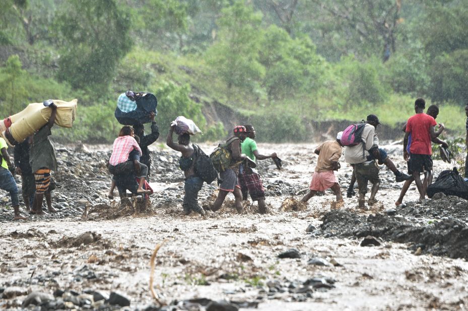 People cross the La Digue river on October 5.