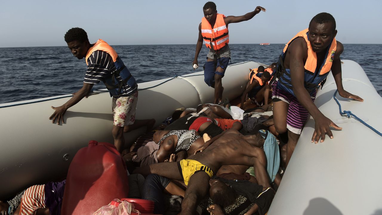 Migrants step over dead bodies while being rescued in the Mediterranean Sea, off the coast of Libya in October 2016.  Agence France-Presse photographer Aris Messinis <a href=