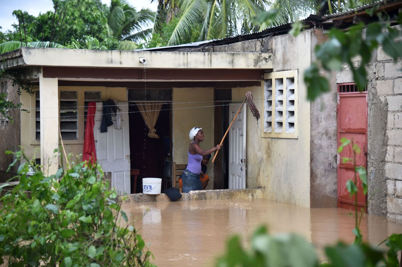 A woman cleans her flooded home following the overflowing of La Rouyonne River on October 5 in Leogane. Residents could face risks from standing water. Haiti is still recovering from a cholera outbreak after the devastating 2010 earthquake.