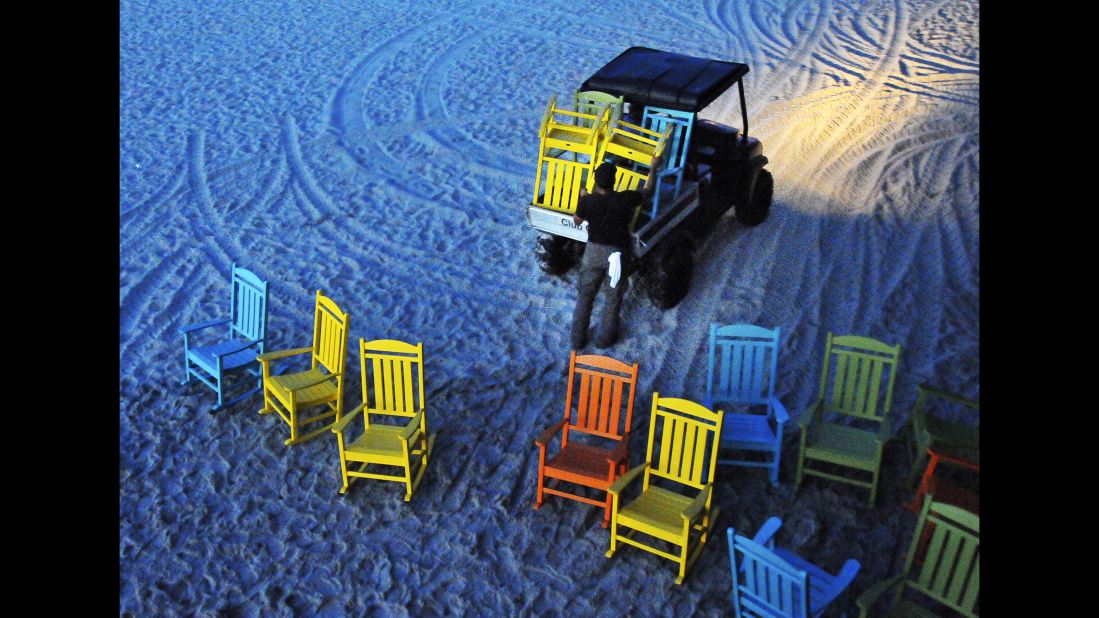 Workers start removing umbrellas and the colorful rocking chairs that line the Cocoa Beach Pier in Cocoa Beach, Florida, on October 5.