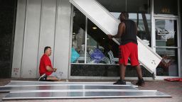 Jason Brock and Kevin Hunter put up hurricane shutters in front of a business as Hurricane Matthew approaches the area on Thursday, October 6 in Delray Beach, Florida.  