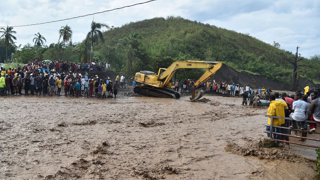 Haitians wait to cross the river in Petit Goave where a bridge collapsed cutting off a main route to the devastated south of the country