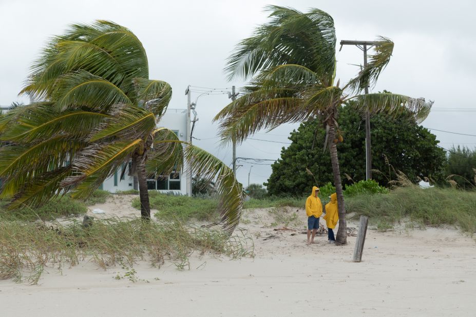 People stand on a beach in Broward County, Florida, as the storm approached the coast on Thursday, October 6.
