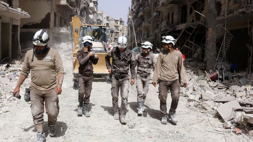 Syrian civil defence volunteers, known as the White Helmets, walk amidst the debris following a reported air strike by Syrian government forces in the rebel-held neighbourhood of Sukkari in the northern city of Aleppo on June 3, 2016.
Regime air strikes killed dozens of civilians in the Syrian city of Aleppo and nearby areas as the UN Security Council prepared to discuss emergency aid drops to besieged areas. / AFP / THAER MOHAMMED        (Photo credit should read THAER MOHAMMED/AFP/Getty Images)