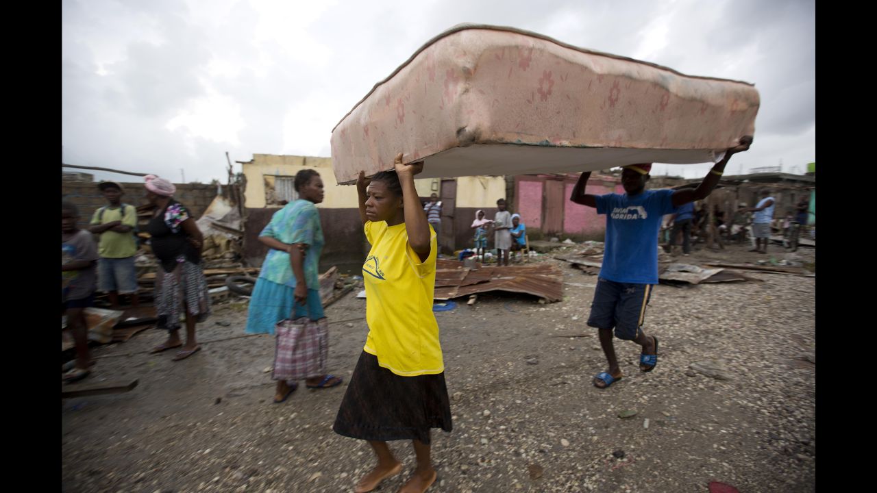 Residents take a mattress to a shelter after homes were destroyed in Les Cayes, Haiti.