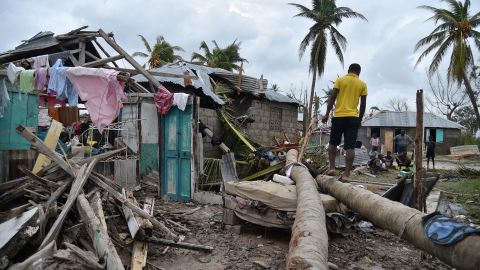 A young man walks on a palm tree in front of a destroyed house in Croix Marche-a-Terre, in south-west Haiti.