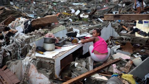 A woman searches amid the rubble of her home destroyed by Hurricane Matthew in Baracoa, Cuba, Wednesday, Oct. 5.