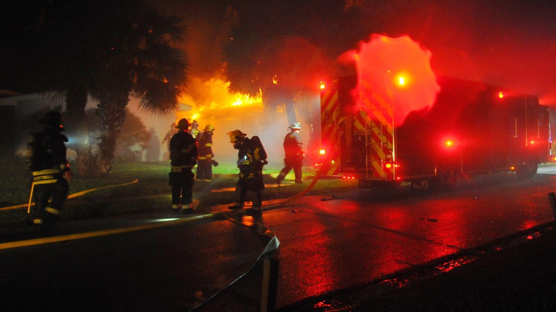 Firefighters respond to a pre-dawn house fire in Satellite Beach, Florida, that was possibly caused by a downed power line on October 7.
