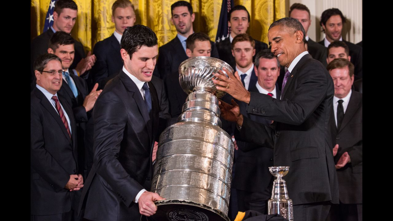 President Barack Obama helps Pittsburgh Penguins captain Sidney Crosby move the Stanley Cup during the hockey team's visit to the White House on Thursday, October 6.