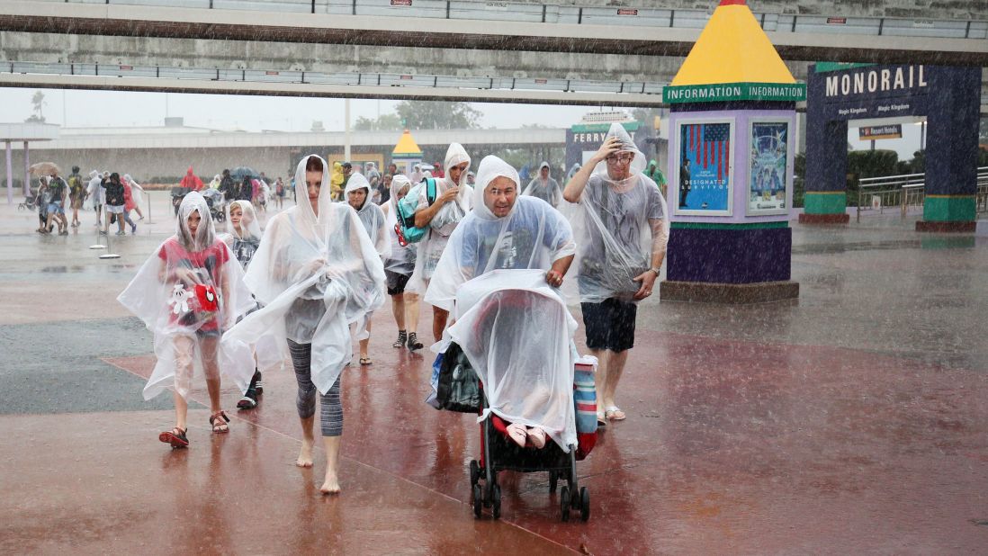 People leave Disney's Magic Kingdom theme park, in heavy rain, after it closed in Orlando, Florida in preparation for the landfall of Hurricane Matthew, on October 6.