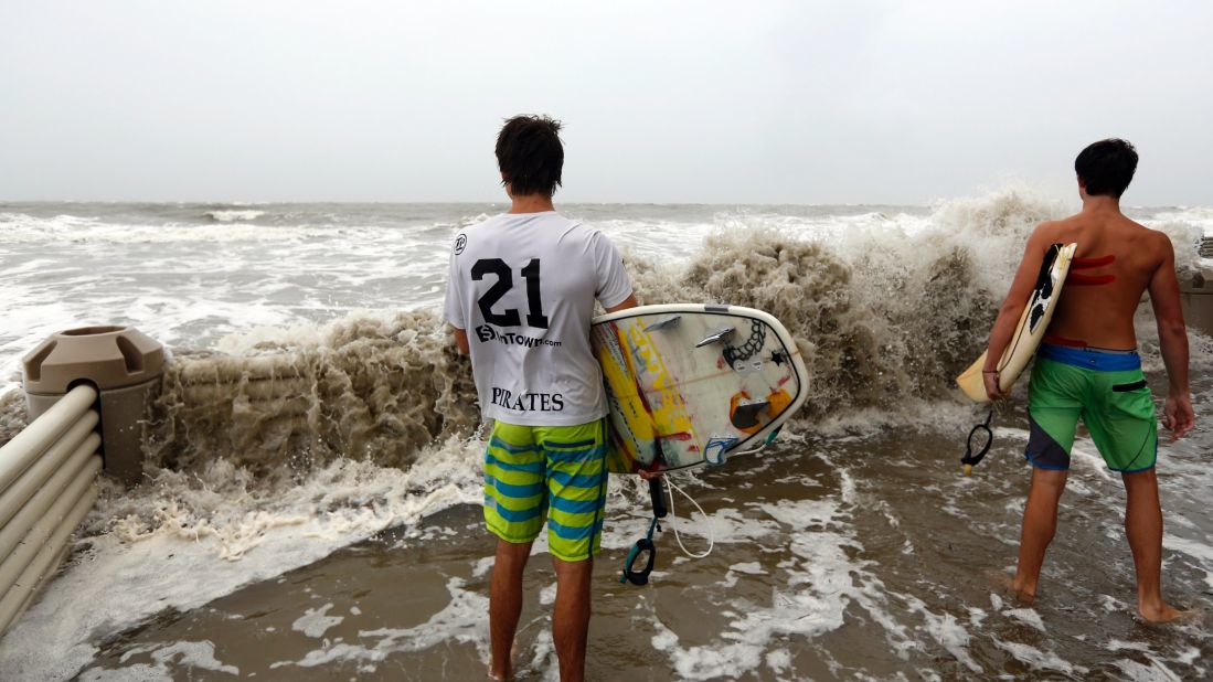 Adam and Alec Selent watch waves crash over a retainer wall at the Ocean Club condominiums in Isle of Palms, South Carolina, on October 7.