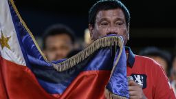 Presidential candidate and Davao Mayor Rodrigo Duterte kisses his national flag as he addresses his supporters during an election campaign rally ahead of the presidential and vice presidential elections in Manila on May 7, 2016.