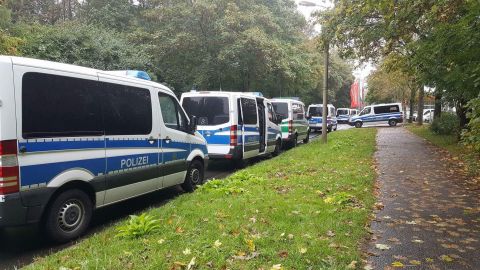 Police vehicles are lined up in front of an apartment building Saturday in Chemnitz