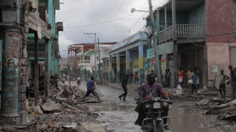 Haitians gather along a flooded street in Haiti on Friday, October 7.