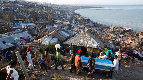 Residents try to move the remains of a pregnant woman killed by Hurricane Matthew in Jeremie, Haiti. 