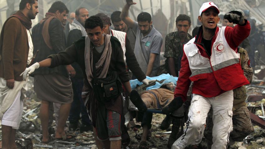 Yemeni rescue workers carry a victim on a stretcher amid the rubble of a destroyed building following reported airstrikes by Saudi-led coalition air-planes on the capital Sanaa on October 8, 2016.Rebels in control of Yemen's capital accused the Saudi-led coalition fighting them of killing or wounding dozens of people in air strikes on Sanaa. The insurgent-controlled news site sabanews.net said that coalition planes hit a building in the capital where people had gathered to mourn the death of an official, resulting in "dozens of dead or wounded". / AFP / MOHAMMED HUWAIS        (Photo credit should read MOHAMMED HUWAIS/AFP/Getty Images)