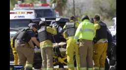 Emergency personnel wearing bullet-proof vests attend to a person on a stretcher on the corner of Cypress Road and Del Lago Road in Palm Springs, Calif. on Saturday, Oct. 8, 2016. Palm Springs police say three officers had been shot but did not give their conditions. (Omar Ornelas/The Desert Sun via AP)
