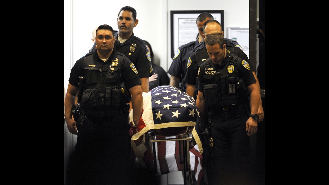 Palm Springs police officers carry the body of a fellow officer from a hospital to a hearse bound for the coroner's office Saturday in Indio, California. 