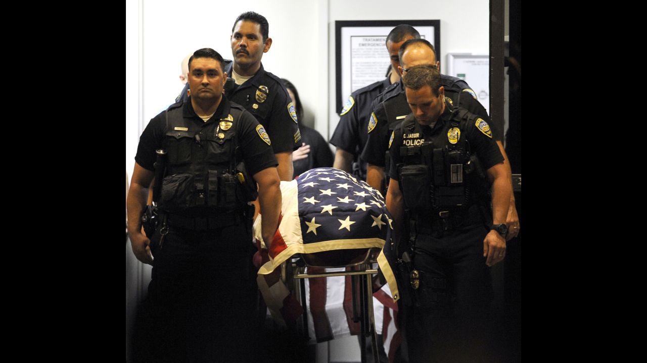 Palm Springs police officers carry the body of a fellow officer from a hospital to a hearse bound for the coroner's office Saturday in Indio, California.
