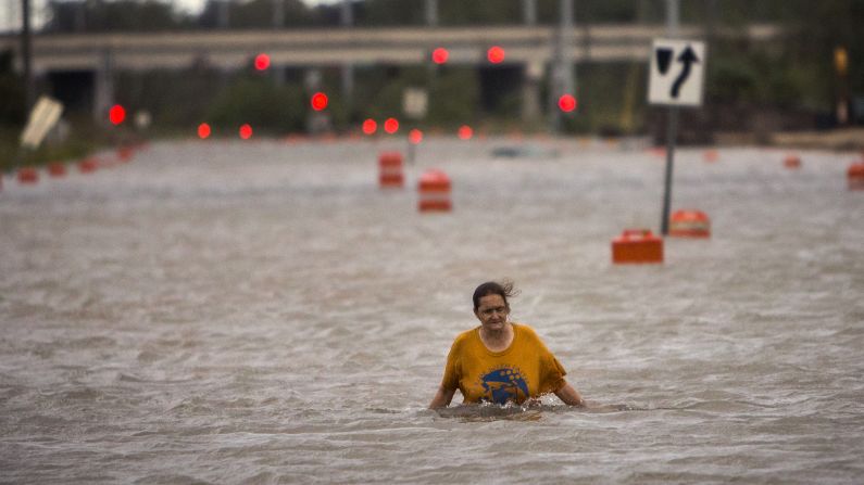 A woman who gave her name only as Valerie walks along flooded President Street after leaving her homeless camp in Savannah, Georgia, on October 8.