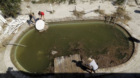 Volunteers clear debris from from a pool at a condominium complex in Jacksonville Beach, Florida, on October 8.