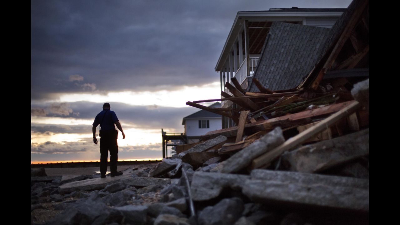 A police officer steps through the remnants of a home leveled by Hurricane Matthew in the tiny beach community of Edisto Beach, South Carolina, on October 8.