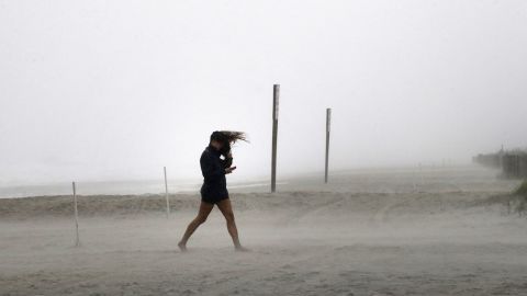 A woman fights the wind in Wrightsville Beach, North Carolina, on October 8.