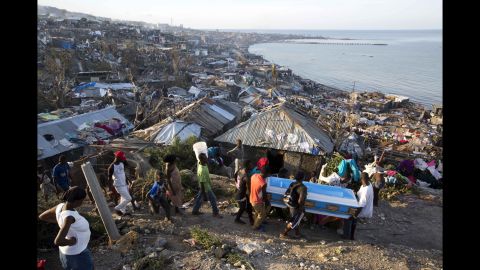 Residents carry a coffin containing the remains of a pregnant woman, a victim of Hurricane Matthew, in Jeremie on Friday, October 7. People across southwest Haiti were digging through the wreckage of their homes Friday, salvaging what they could of their meager possessions.